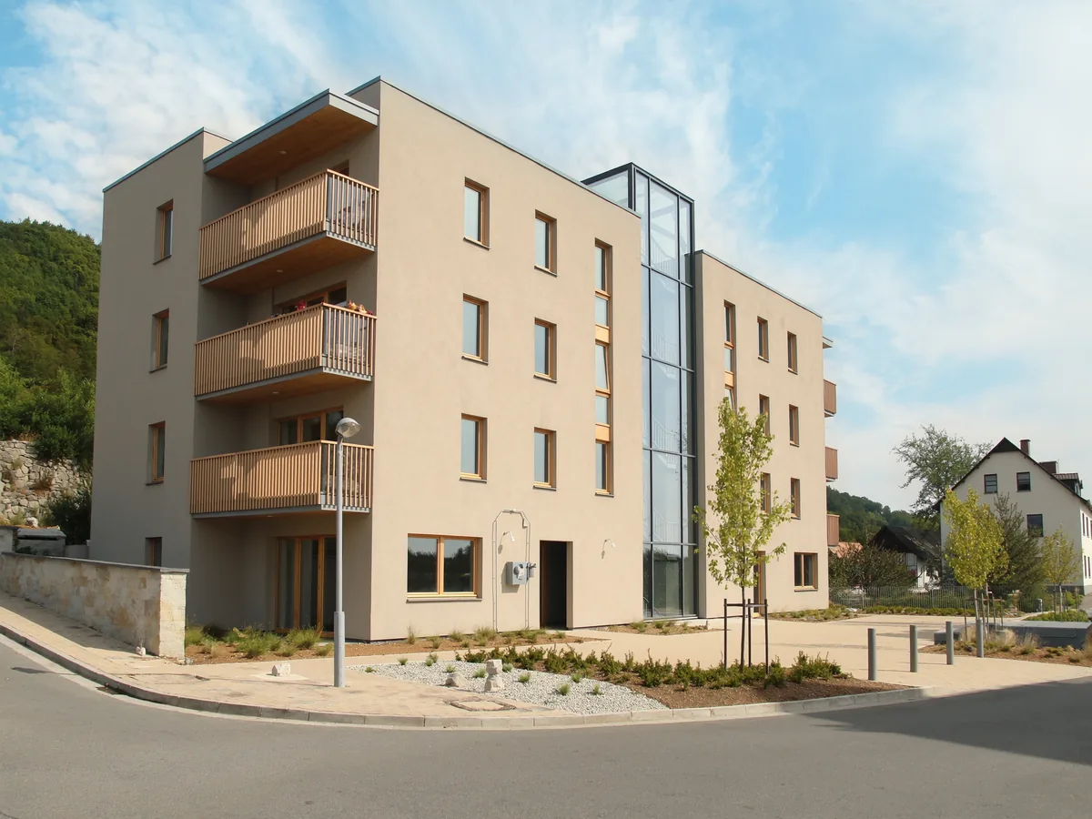 Neubau-Mehrfamilienhaus in Wendlingen mit Holzbalkonen und großen Fenstern